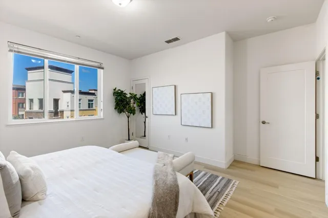 a bedroom with a bed and a potted plant