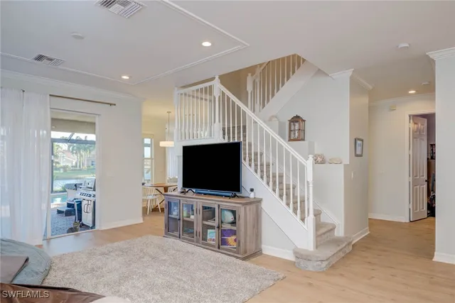 a living room with wooden floor and a flat screen tv