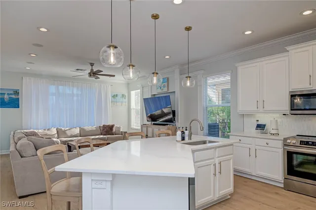 a kitchen with stainless steel appliances kitchen island granite countertop a sink a stove a dining table and chairs