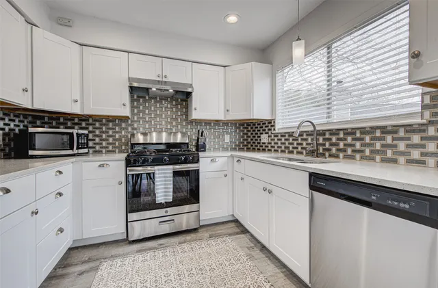 a kitchen with granite countertop white cabinets and white appliances