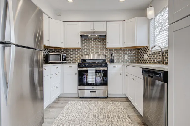 a kitchen with a stove top oven and refrigerator