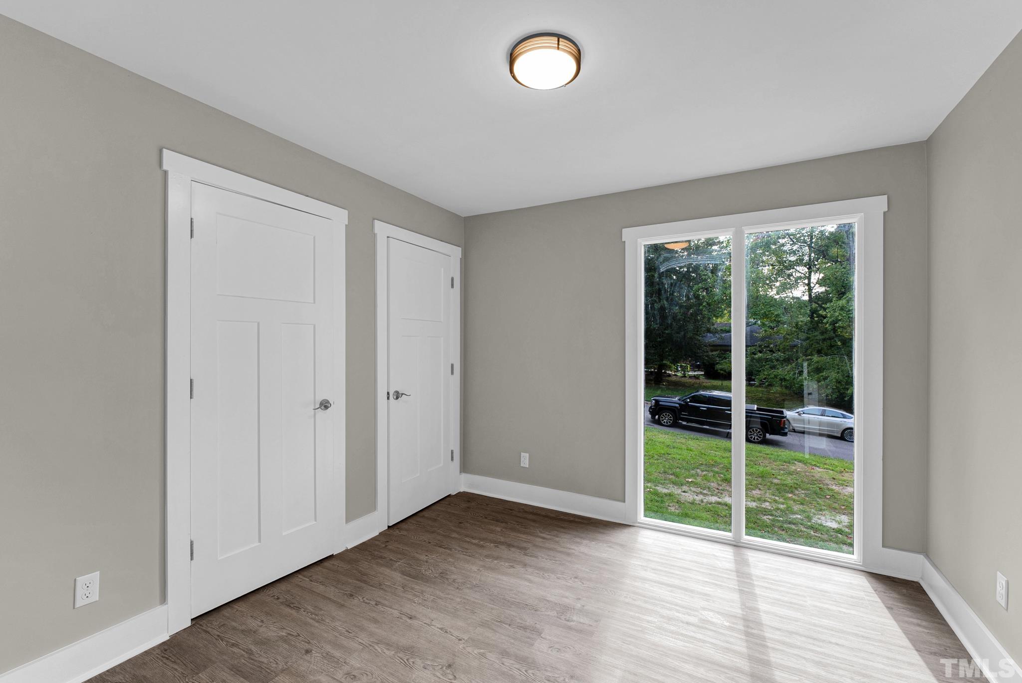 6712 Millbridge Court Raleigh, NC 27615 - Photo 13 of 25 an empty room with wooden floor and windows