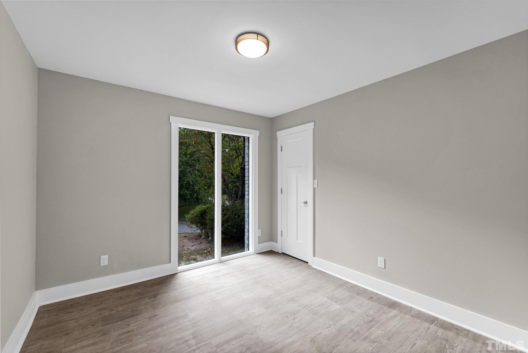 6712 Millbridge Court Raleigh, NC 27615 - Photo 15 of 25 wooden floor in an empty room with a window