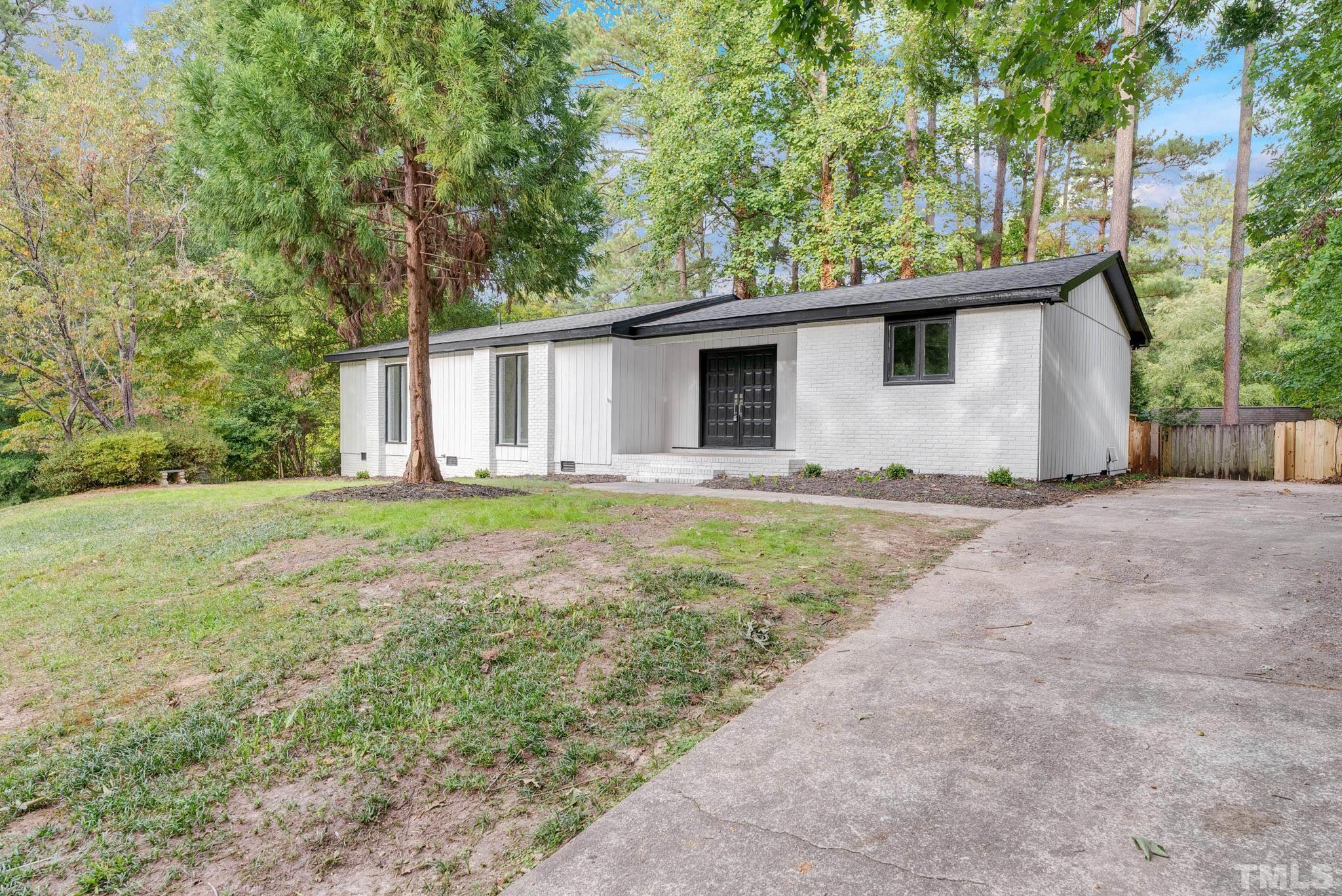 6712 Millbridge Court Raleigh, NC 27615 - Photo 2 of 25 a white house that has a tree in front of it