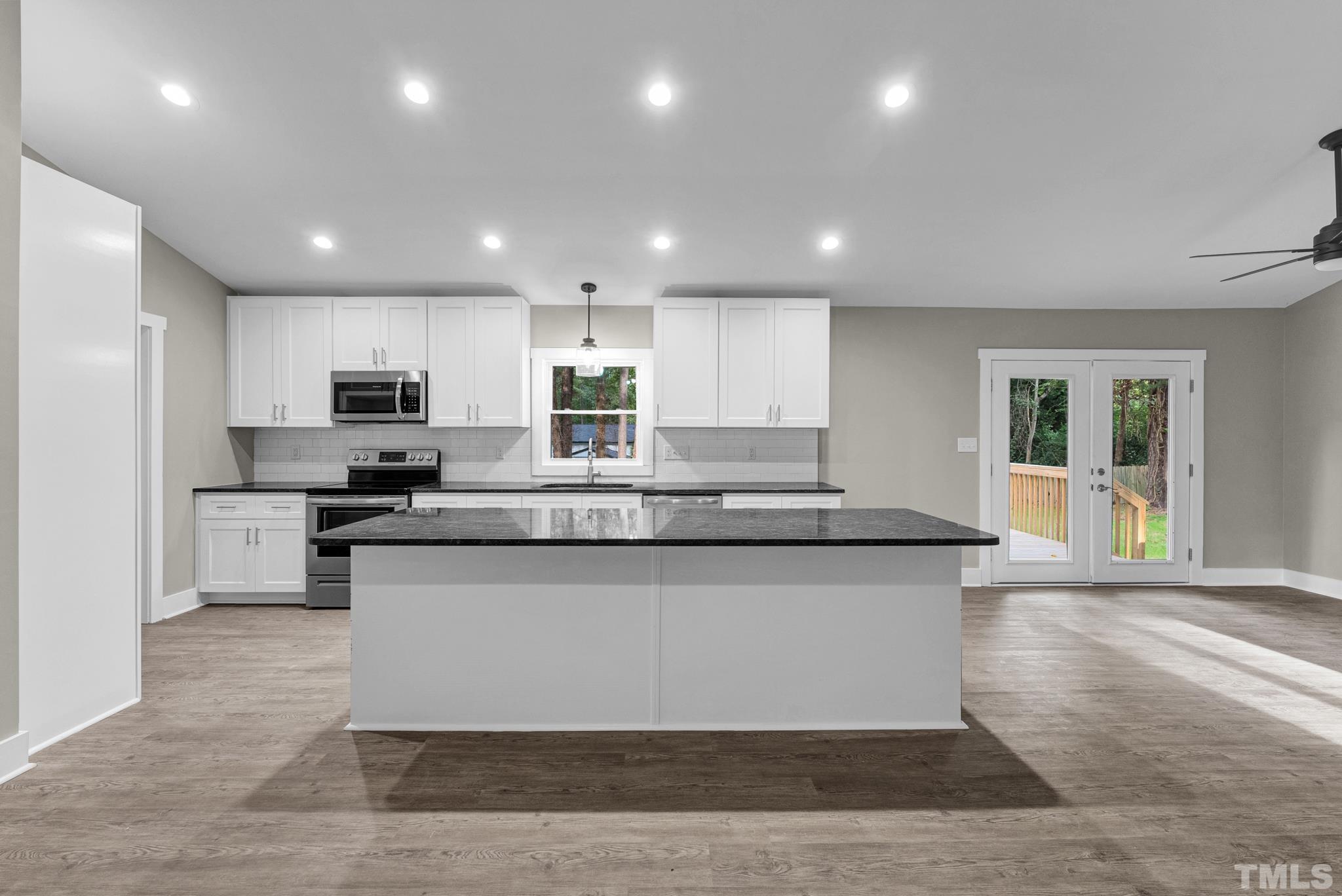 6712 Millbridge Court Raleigh, NC 27615 - Photo 3 of 25 a large kitchen with granite countertop lots of counter top space and stainless steel appliances