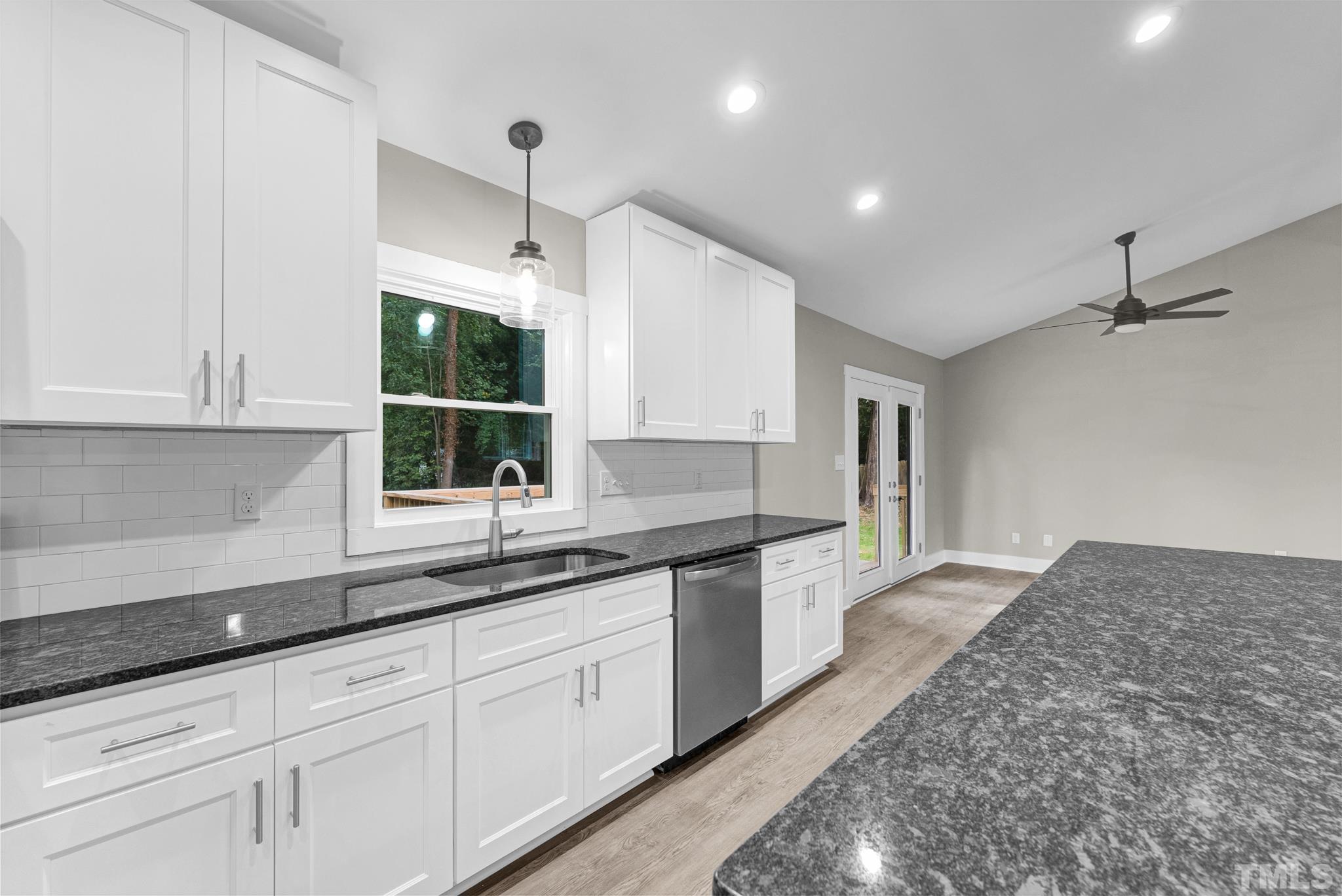 6712 Millbridge Court Raleigh, NC 27615 - Photo 4 of 25 a kitchen with granite countertop white cabinets and white appliances