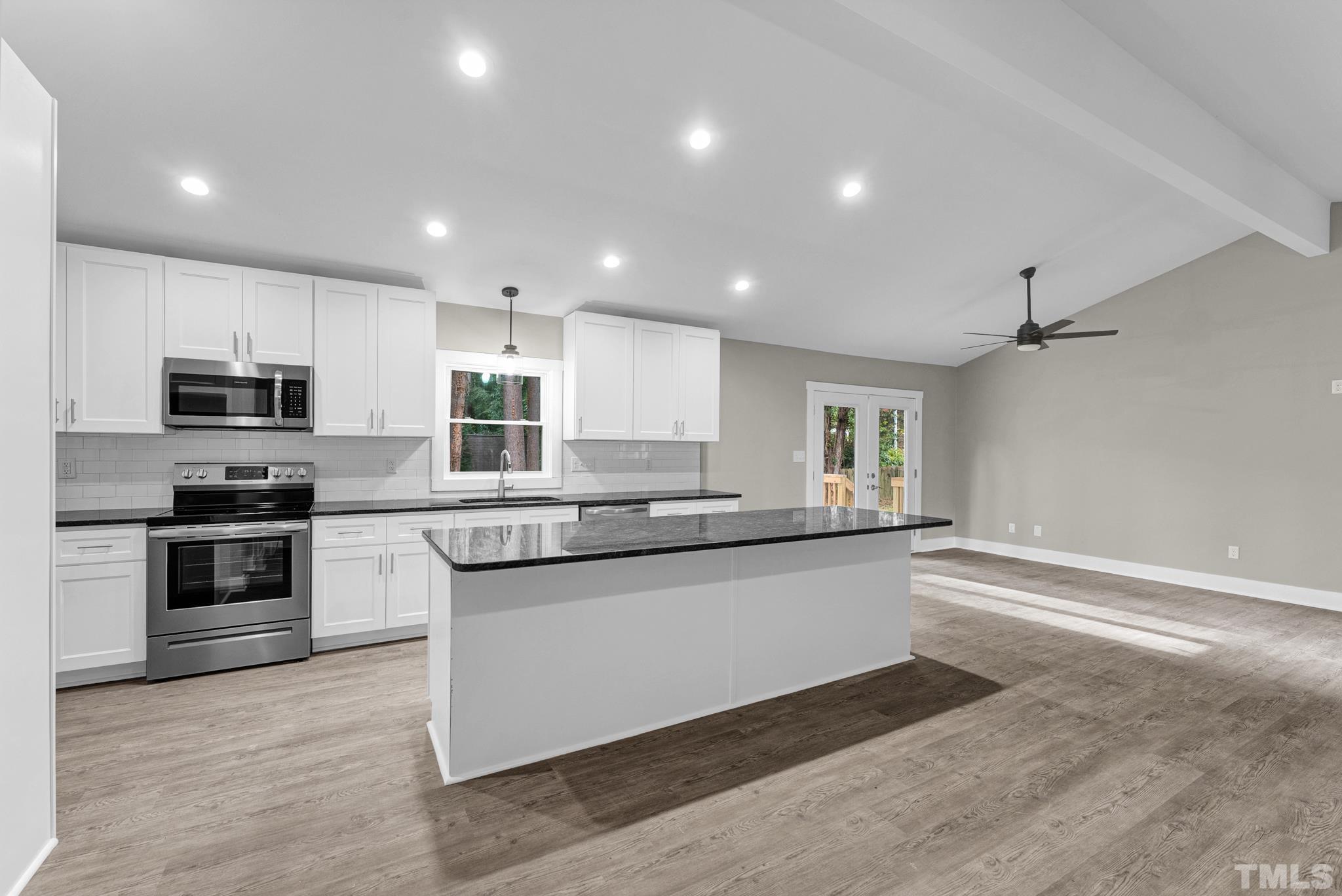 6712 Millbridge Court Raleigh, NC 27615 - Photo 6 of 25 a kitchen with granite countertop a sink and steel appliances