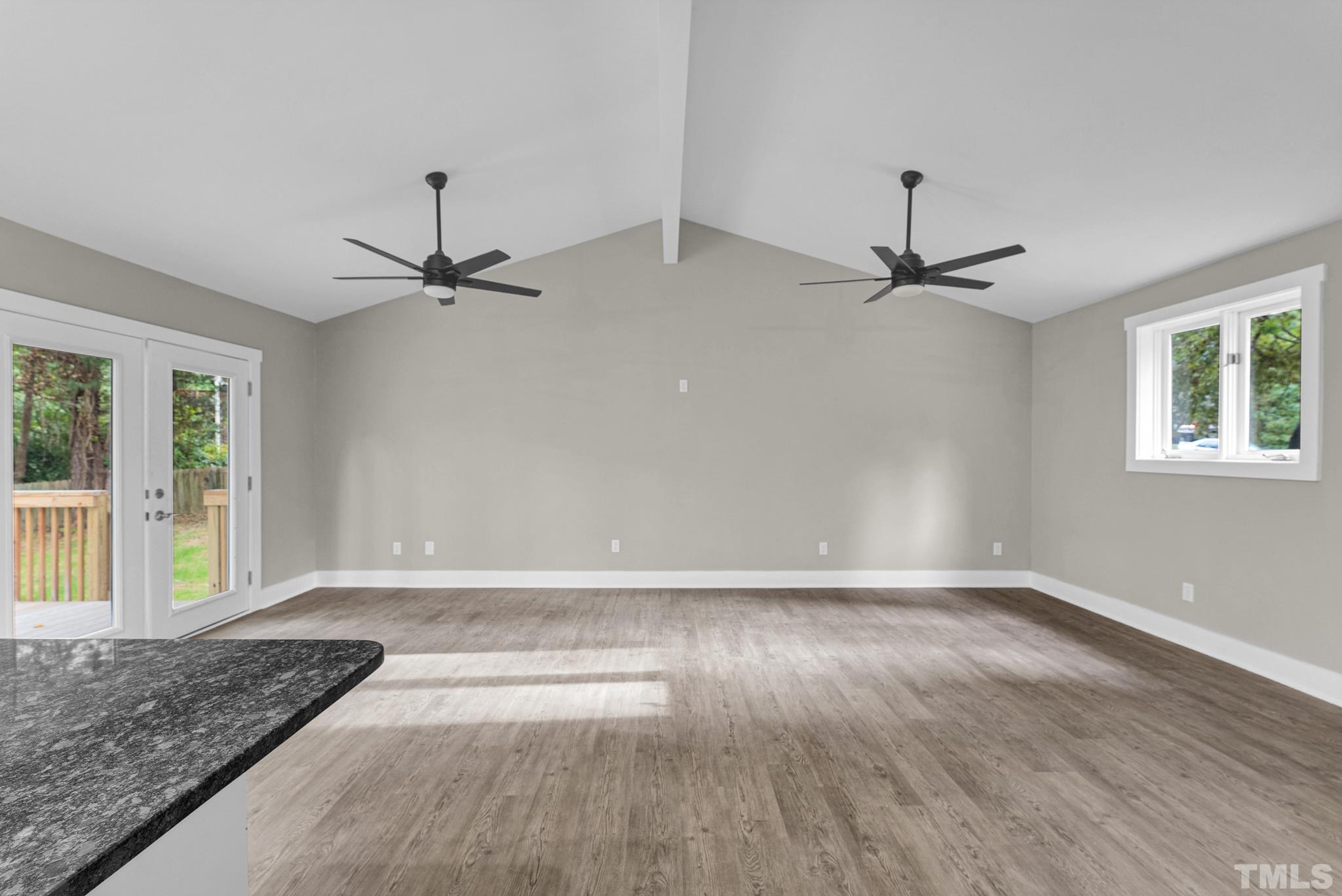 6712 Millbridge Court Raleigh, NC 27615 - Photo 7 of 25 a view of an empty room with a window and wooden floor