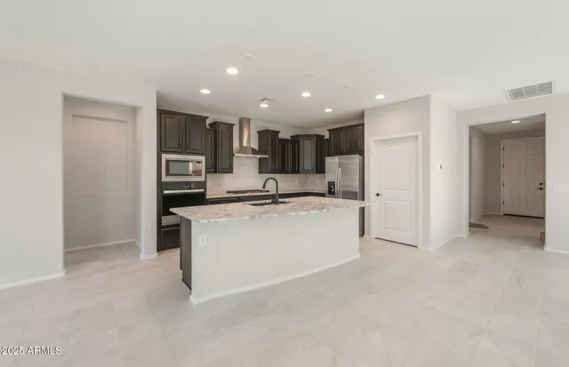 a view of kitchen with kitchen island stainless steel appliances a sink and cabinets