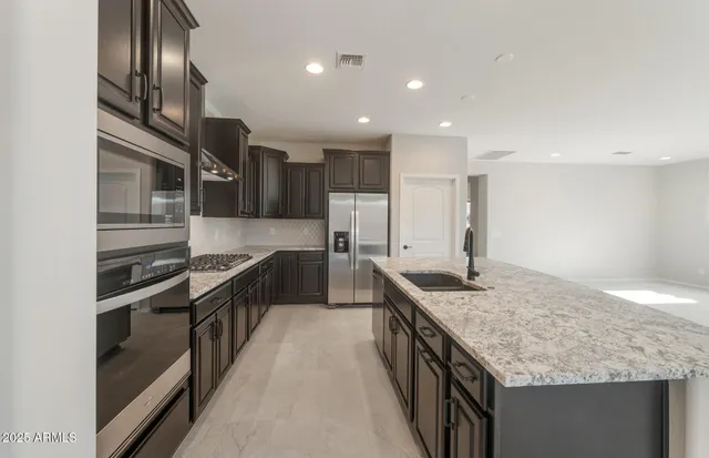 a view of kitchen with kitchen island a sink a stove and a refrigerator