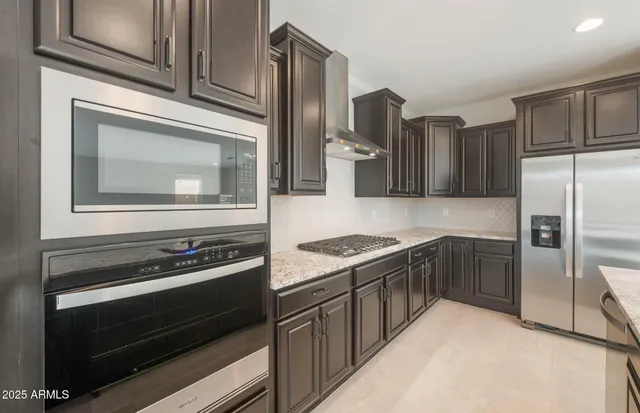 a kitchen with stainless steel appliances granite countertop sink stove and refrigerator