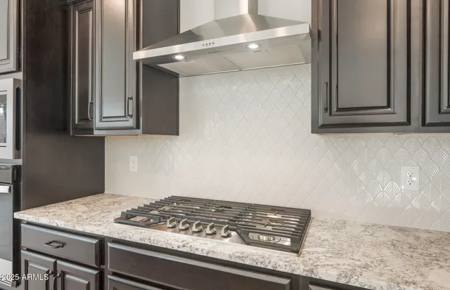 a kitchen with stainless steel appliances granite countertop a stove microwave and refrigerator