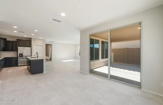 an empty room with floor to ceiling windows and chandelier
