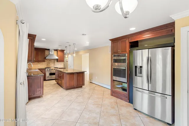 a kitchen with stainless steel appliances granite countertop a refrigerator and a stove