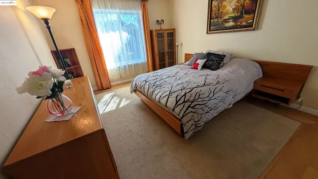 a bedroom with a bed and dresser with mirror