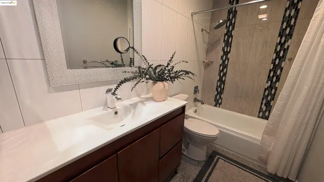 a bathroom with a sink a toilet a mirror and shower