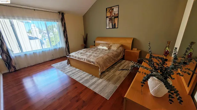 a bed sitting in a bedroom next to a window