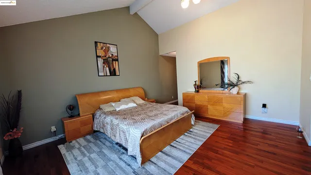 a bedroom with bed and wooden floor