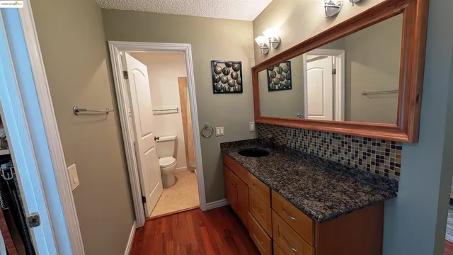 a bathroom with a granite countertop sink and a mirror