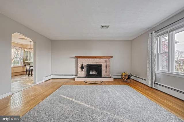 a view of an empty room with a fireplace and a window