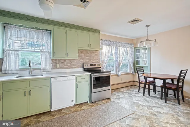 a kitchen with a stove a sink and a dining table
