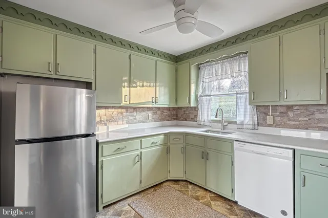 a kitchen with a sink stainless steel appliances cabinets and a window