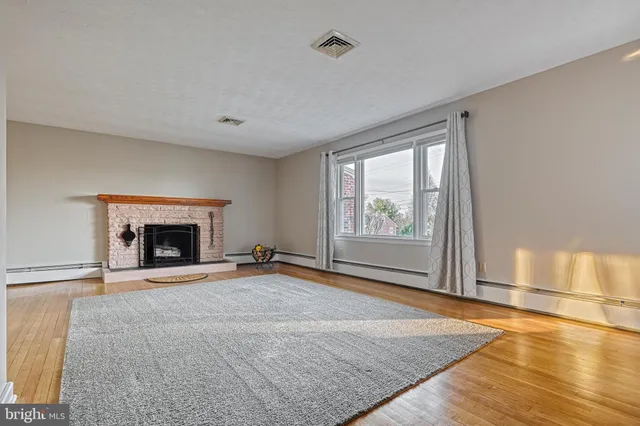 a view of an empty room with window and fire place