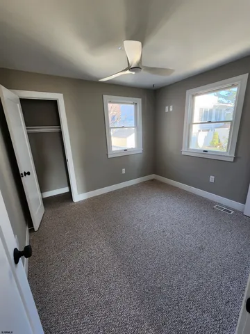 an empty room with windows and closet