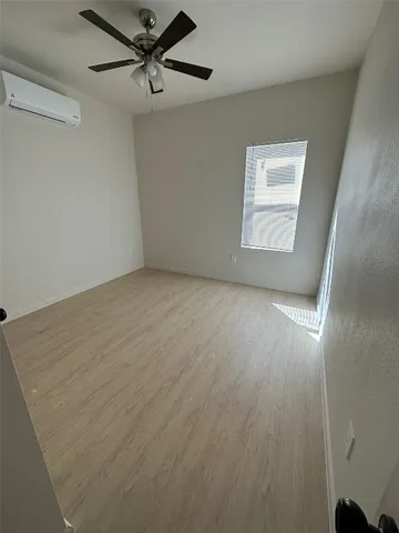 an empty room with windows and fan