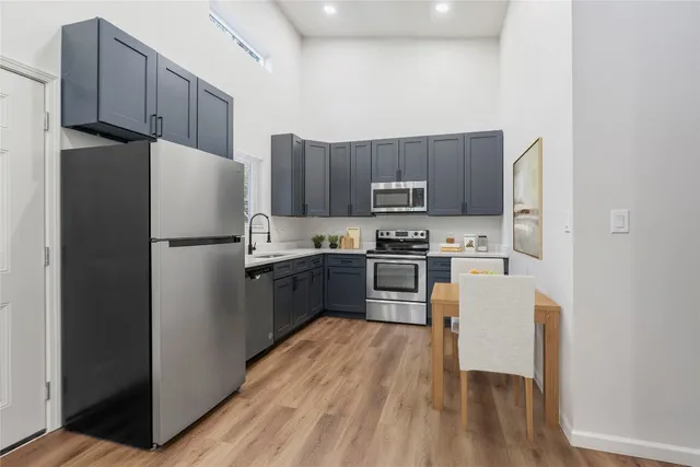 a kitchen with stainless steel appliances a refrigerator stove microwave and sink