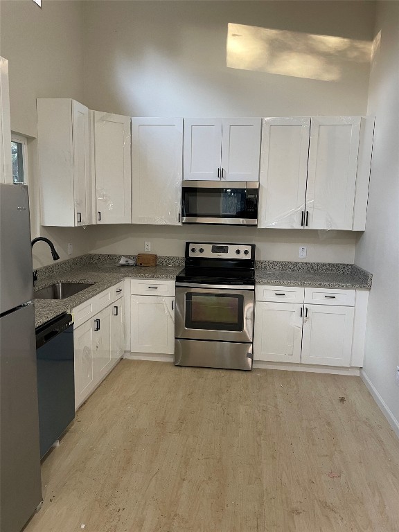 23081 Nameless Road, Unit I Leander, TX 78641 - Photo 5 of 15 a white kitchen with granite top and stainless steel appliances