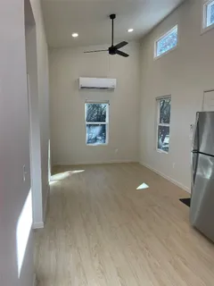a view of an empty room with a window and wooden floor