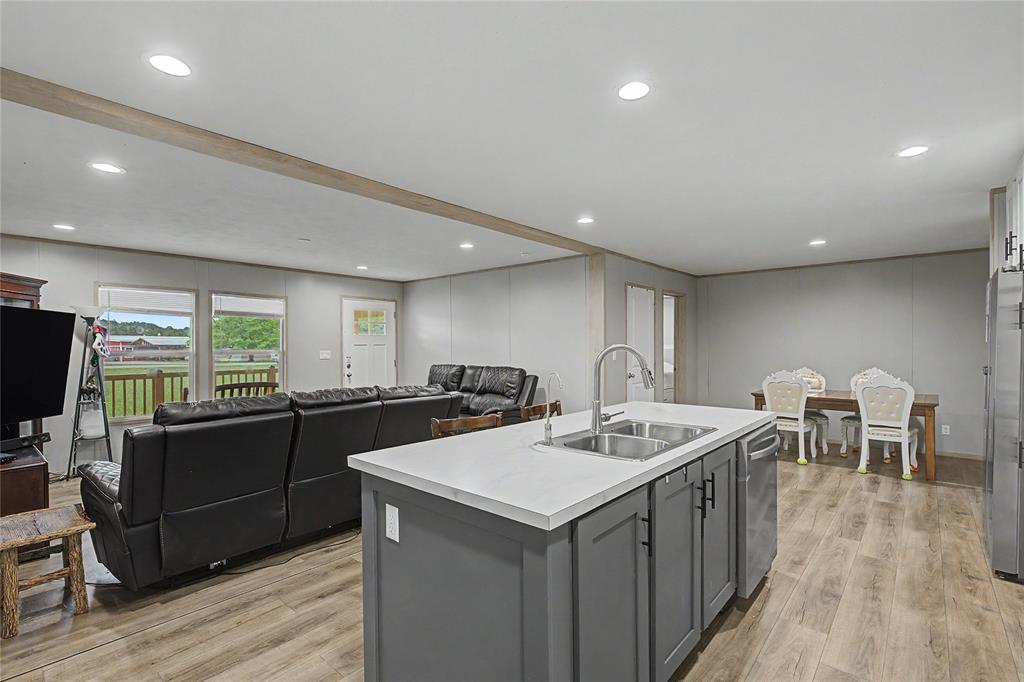 6065 Timber Trail Azle, TX 76020 - Photo 11 of 33 a kitchen with stainless steel appliances granite countertop a sink counter space and wooden floor