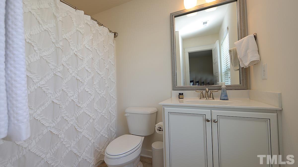 6414 Swatner Drive Raleigh, NC 27612 - Photo 11 of 21 a bathroom with a toilet sink and mirror