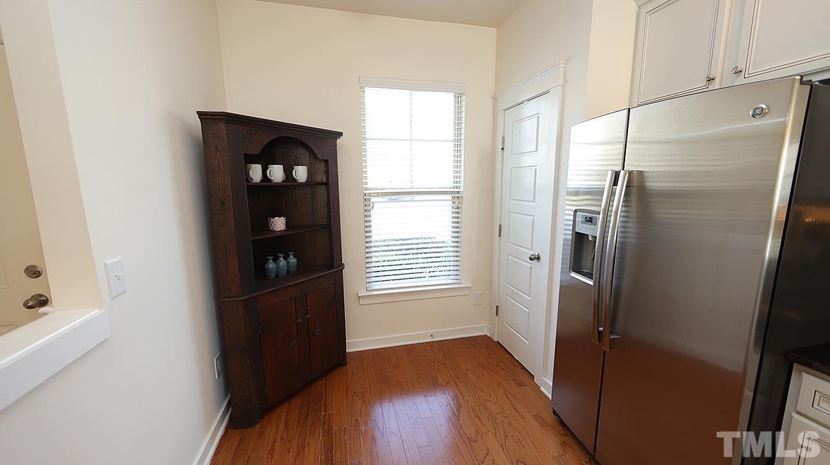 6414 Swatner Drive Raleigh, NC 27612 - Photo 3 of 21 a kitchen with a refrigerator and a wooden floor