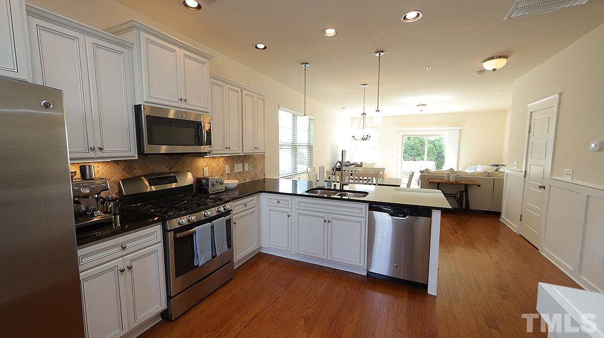 6414 Swatner Drive Raleigh, NC 27612 - Photo 4 of 21 a kitchen with stainless steel appliances granite countertop wooden cabinets a sink a stove a refrigerator and microwave