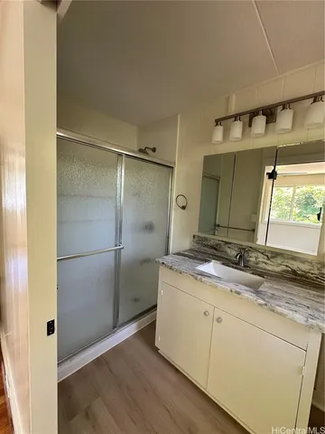 a bathroom with a granite countertop sink and a mirror