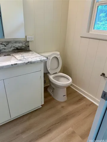a bathroom with a granite countertop toilet and a sink