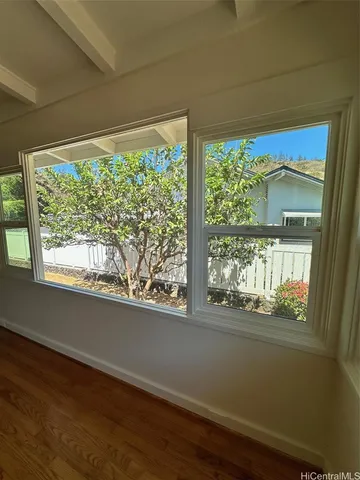 a view of a room with wooden floor and a window