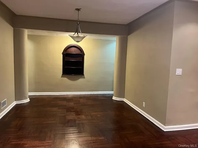a room with wooden floor ceiling fan and window