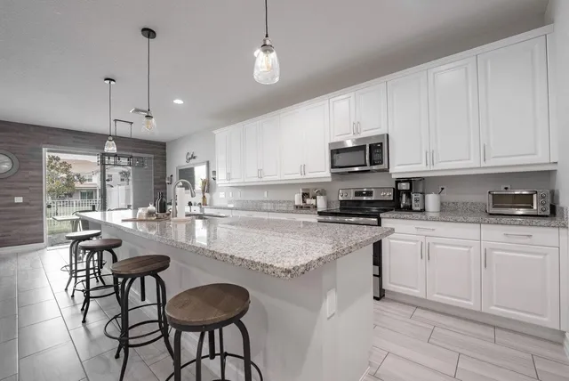 a large kitchen with kitchen island a sink stainless steel appliances and a counter top