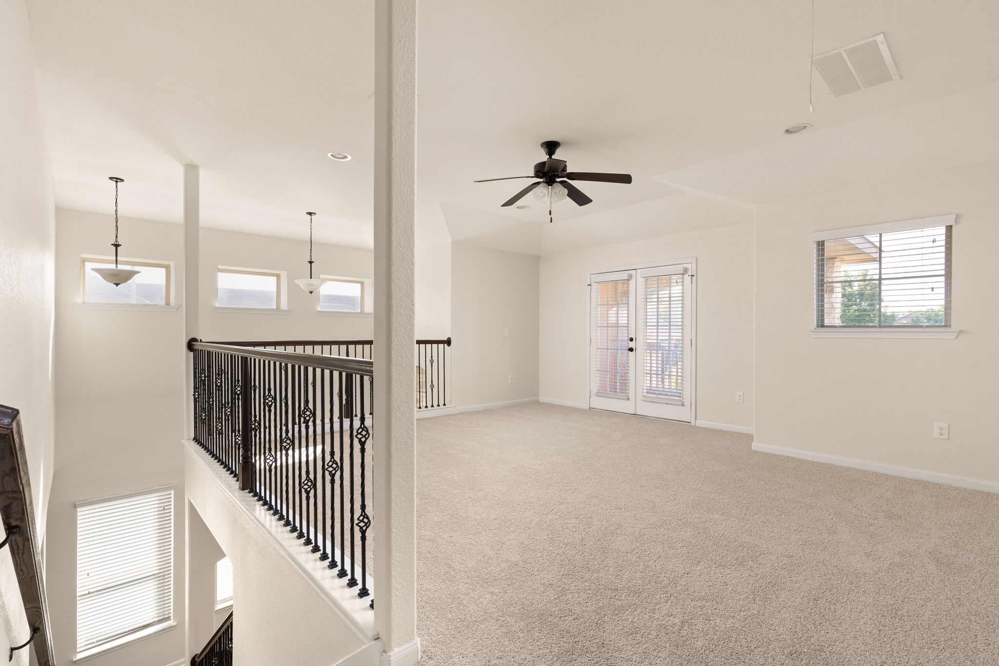 2400 Leonards Pass Leander, TX 78641 - Photo 20 of 40 A versatile upstairs loft with carpeted floors and a door leading to a balcony.
