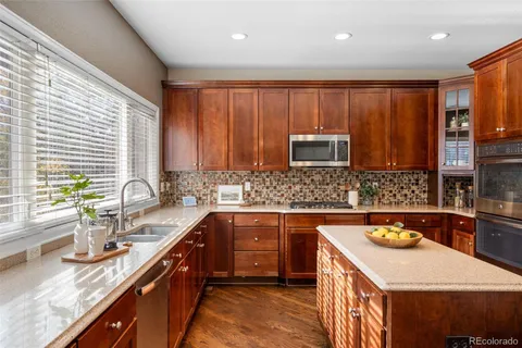 a kitchen with stainless steel appliances granite countertop a sink stove and cabinets