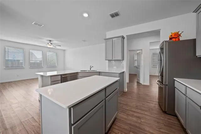 a kitchen with a refrigerator a sink and dishwasher with wooden floor