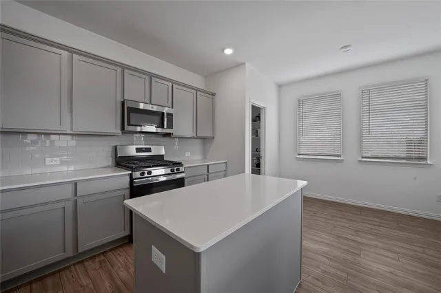 a kitchen with stainless steel appliances a white stove top oven sink and cabinets