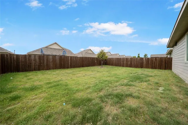 a front view of a house with yard and wooden fence