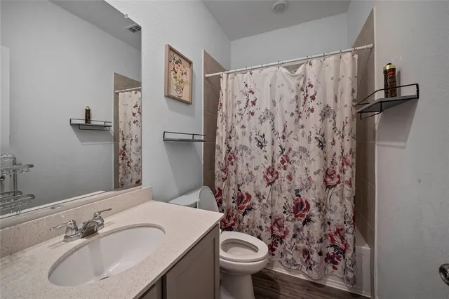 a bathroom with a sink and mirror with toilet