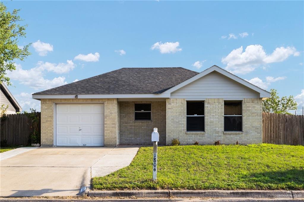 1804 Grayson Avenue McAllen, TX 78504 - Photo 1 of 1 Ranch-style house with concrete driveway, fence, a front lawn, brick siding, and a garage