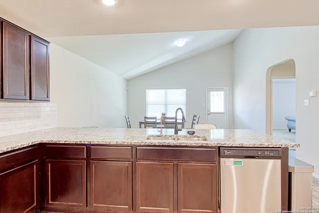 a kitchen with granite countertop cabinets stainless steel appliances and a sink