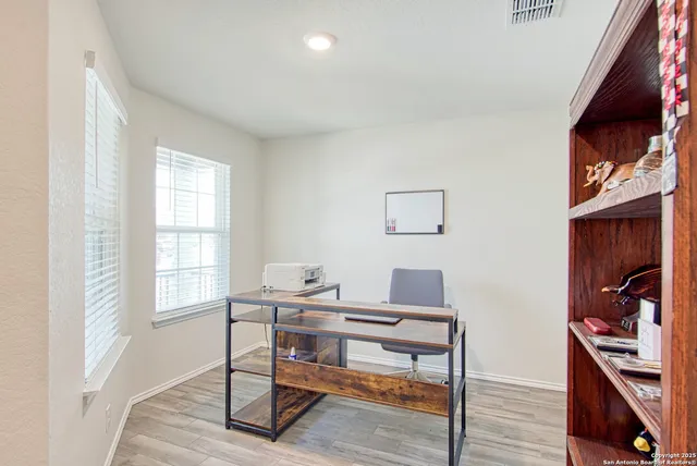 a view of a workspace with furniture and a window